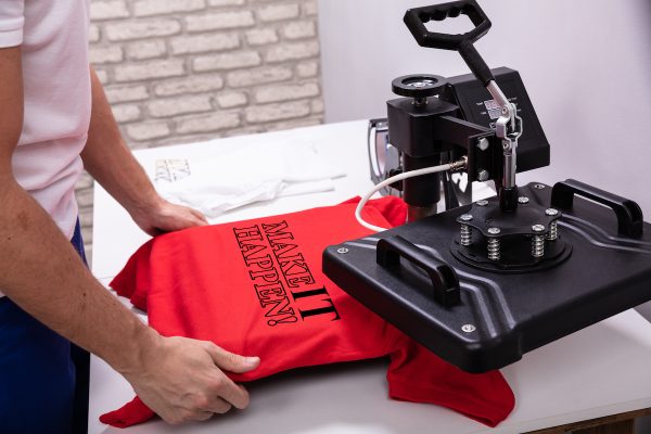 Man printing on t shirt in workshop